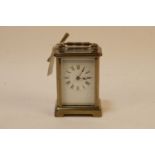 A late 19th century brass carriage clock, the white enamel dial with Roman numerals, fitted swing