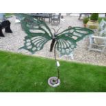 A steel garden sculpture in the form of a butterfly, with pierced wings, and on scrolling stand,