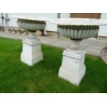 A pair of shallow cast metal and white painted campana urns on stands, each with reeded body