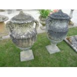 A pair of composition garden urns, each in two parts, 80cm high (missing finials)