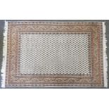 A hand knotted Persian rug, the biscuit fields with repeated geometric motifs, within a multi