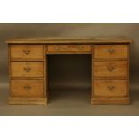 A pine pedestal desk, with a leather top, over seven drawers, 152cm