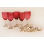 A collection of hallmarked silver teaspoons and a set of five cranberry glasses (qty)