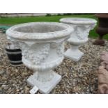 A pair of 20th century white painted cast stone planters, decorated with fruit and floral swags,