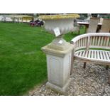 A reconstituted stone garden urn on a square plinth, urn 116cm high