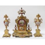 A late 19th century French gilt metal and porcelain mantel clock, the urn surmount above circular