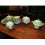 A Victorian porcelain dinner service, having a green banded border, including tureens and meat