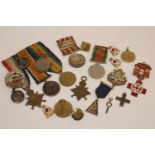 A collection of First and Second World War medals and badges, to include a First World War medal