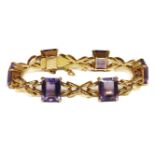 A gold emerald cut amethyst bracelet, claw set to a cross link bracelet, marked 18k (tested as