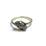 A gold three stone diamond crossover ring, marked 9ct and plat