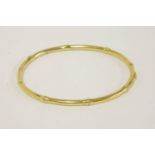 An Edwardian hinged gold bamboo bangle, stamped 15, tested as approximately 15ct gold, 5.14g