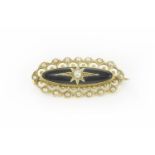 A Victorian gold and black onyx cabochon and seed pearl brooch, the centre seed pearl set to an