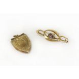 A 9ct gold single stone garnet brooch, and a 9ct gold shield-shaped locket with engraved