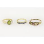 An 18ct gold single stone peridot ring, and a gold five stone garnet and white stone ring marked