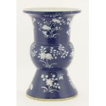 A blue gu vase, late 19th century, in the archaic bronze form enamelled in white with sprigs of