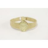 A ladies 9ct gold Tissot mechanical bracelet watch, with baton numerals and integral textured