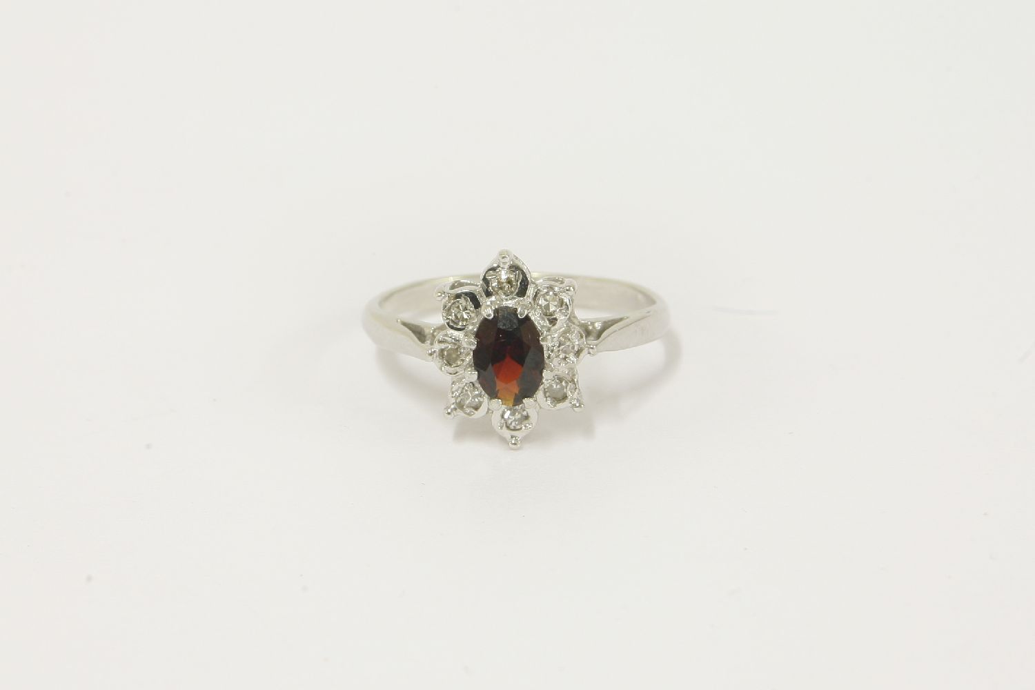 A 9ct white gold garnet and diamond oval cluster ring, size M½2.32g