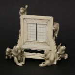 A Japanese ivory table screen,late 19th century, mounted with six monkeys, one wearing a jacket