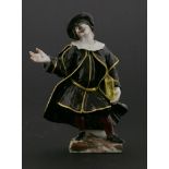 A Capodimonte figure,of a doctor standing with one hand outstretched, the other holding a book,