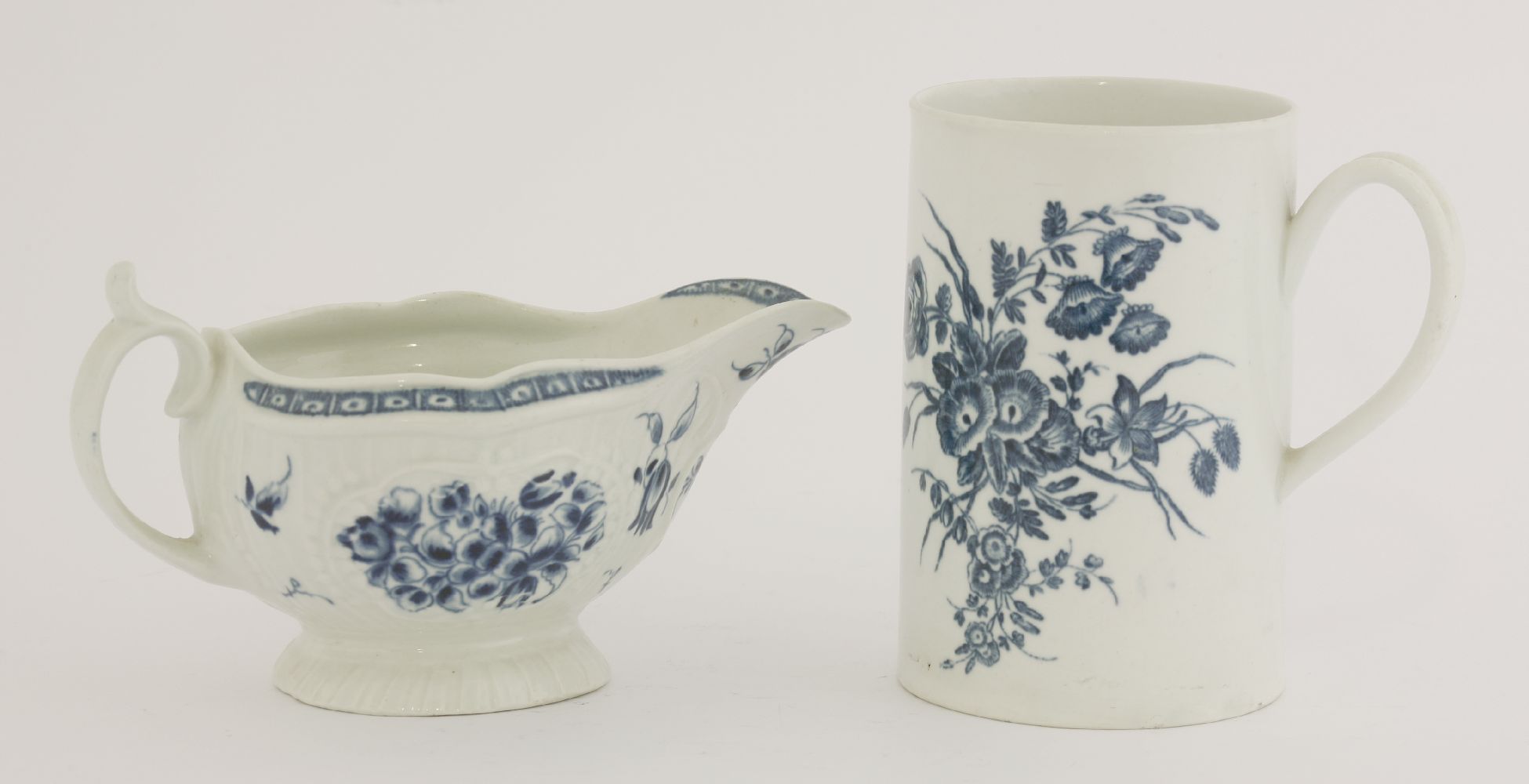 A Worcester blue and white sauce boat,c.1780, painted with a floral pattern on a moulded strap flute