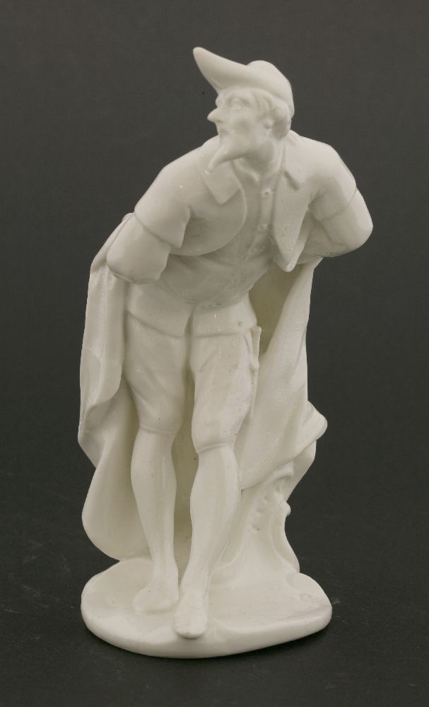 A Komodie white porcelain figure,of Pantalone leaning forward on a shaped circular base, with