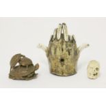 An ivory rosary bead,19th century, carved in the form of a half skull/half face,2.2cm high,a