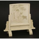 A Japanese ivory table screen, late 19th century, the central panel carved with a boy playing with a