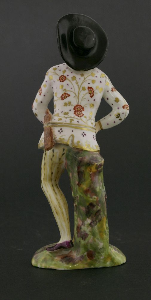 An English ceramic harlequin figure,with slapstick tucked into his belt, raised on a naturalistic - Image 2 of 3