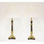 A pair of parcel-gilt candlesticks,with reeded columns and cast gilt triform bases, converted into