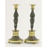 A pair of Regency bronze candlesticks, each formed as a Grecian maiden with folded arms,