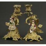 A pair of Minton 'candlestick' figures,mounted on gilt bronze foliate scrolling candlesticks,