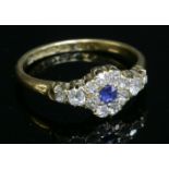 An 18ct gold sapphire and diamond cluster ring with diamond set shoulders,with an oval Swiss cut