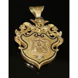 A Victorian gold pendant of cartouche form,with foliate and vine top. A black champlevé enamel