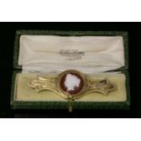 A French gold hardstone cameo bar brooch,with a cameo of a classical lady in white to a dark tan