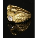 A single stone diamond set chimera or eagle ring,with a dragon holding a brilliant cut diamond in