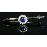 An Edwardian sapphire and diamond cluster head,later mounted to a bar brooch. A circular Swiss cut