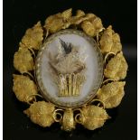 A Victorian gold brooch,with a central glazed oval picture locket with a naturalistic giardinetti