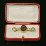 A Victorian Etruscan-style gold barbell and intaglio brooch, c.1870,an oval cornelian intaglio