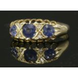 An Edwardian 18ct gold three stone sapphire boat-shaped ring,with pairs of diamond set points,