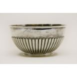 An early 20th century silver bowl of half gadrooned form, marks for London 1903 and a makers mark