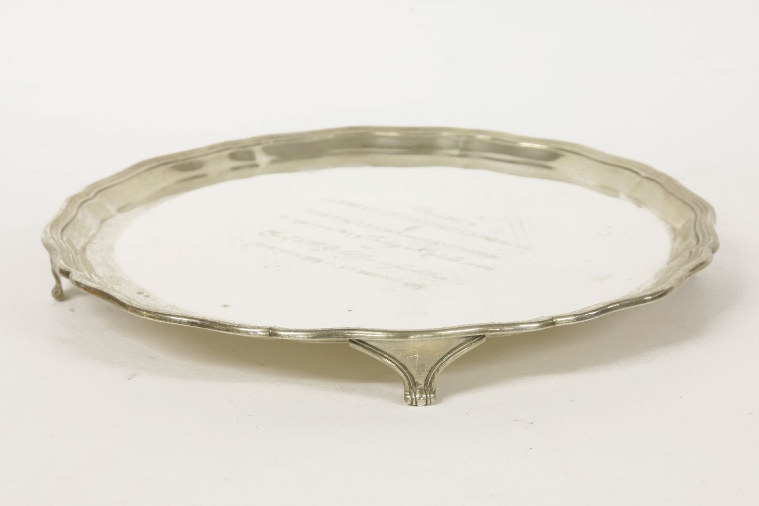 A silver salver, hallmarked, with pie crust border and engraving to centre being presented to Lawrie