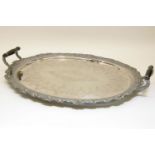 A large Victorian silver plated tray, of oval form with engraved detail, fitted twin ebony handles