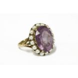 A 9ct gold amethyst and cultured pearl cluster ring, an oval cut amethyst claw set surrounded by