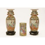 A pair of Chinese famille rose vases, on hardwood stands, 24cm tall, and a cylinder vase