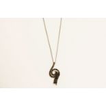 A 9ct white gold black diamond swirl pendant on a trace chain, marked 3751.84g
