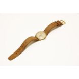 A gentlemen's 9ct gold Accurist mechanical strap watch, a silvered dial with baton numerals