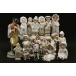 A large collection of porcelain fairing figures, the largest being a piper leaning against a tree