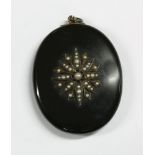 A Victorian black onyx locket, set with applied seed pearl floral spray to reverse and edged in gold