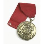 A brass livery medal, crest to front and engraved description to reverse