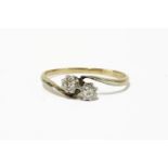 A gold two stone diamond crossover ring, marked 18 and plat1.89g